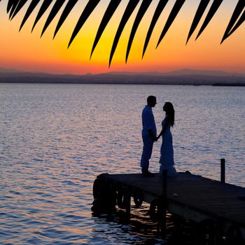 couple in love back light silhouette at lake sunset full length