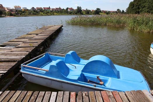 Masuria (Mazury) - famous lake district in Poland. Blue paddle boat (pedalo). Wydminskie lake.
