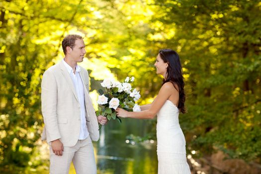 couple in love with white roses bouquet in autumn outdoor river park