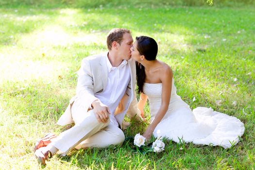 couple happy in love kissing sitting in park green grass