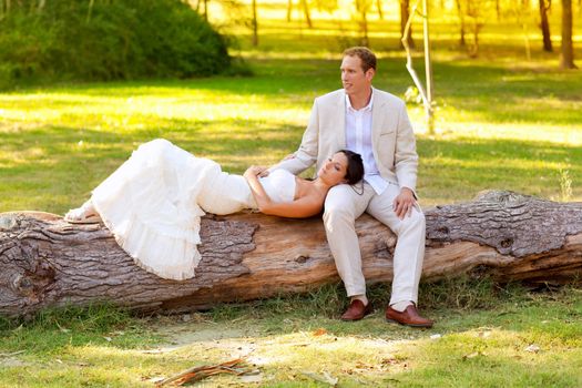 woman lying on husband leg in a park trunk just married