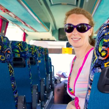 Girl on tourist bus happy with sunglasses in summer vacations