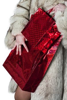 young girl in a fur coat with red bags