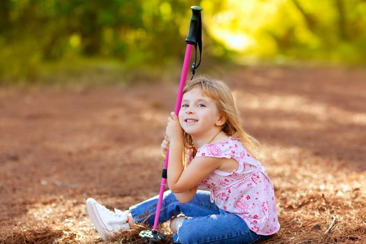 Hiking kid girl tired sitting in autumn forest outdoor