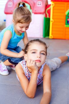 beautiful little little girls lying on floor playing in playground