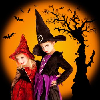 Halloween two children girls with tree and bats on orange background