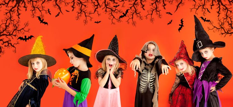 Halloween group of children girls costumes on orange background