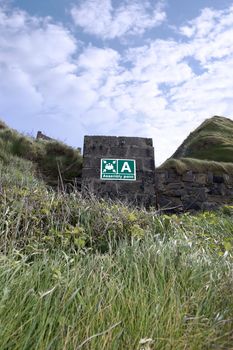 an assembly point sign on a block wall at a beach in Ireland