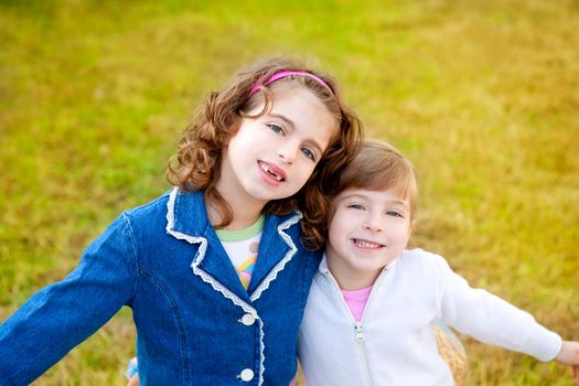 happy sister girls in winter park grass playing together