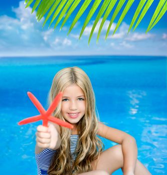 children blond girl in summer vacation tropical beach with starfish