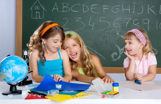 happy laughing student girls group at school classroom desk