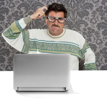 Nerd pensive man with glasses and silly expression in front a laptop computer looking for solution