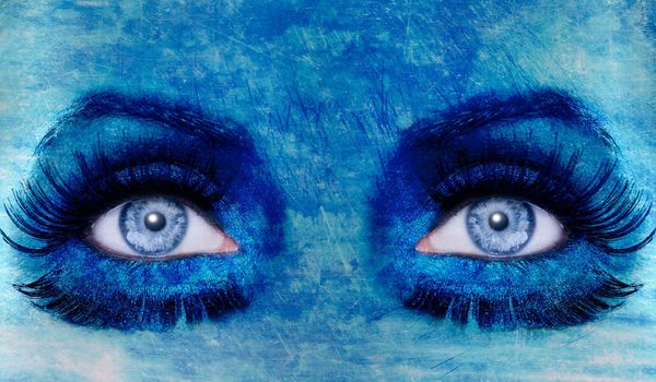 abstract blue woman eyes makeup with a grunge painted wall texture