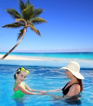 daughter and mother in swimming pool tropical location background