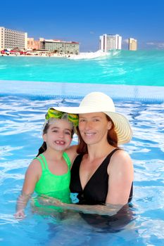 mother and daughter hug in pool tropical beach Caribbean background
