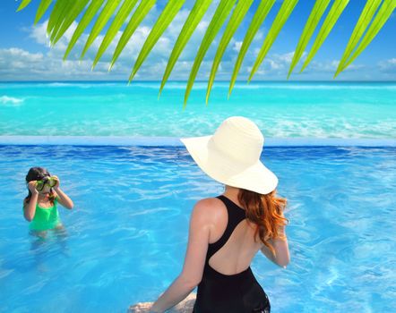 blue swimming pool caribbean view mother and goggles daughter