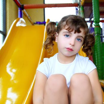 little girl in colorful playground yellow slide children games play