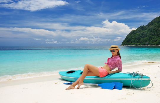 Woman in sunglasses at beach wearing hat