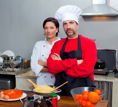 Chef couple man and woman posing in kitchen with uniform