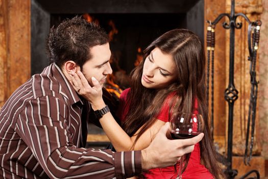 Pretty woman caress her man near fireplace