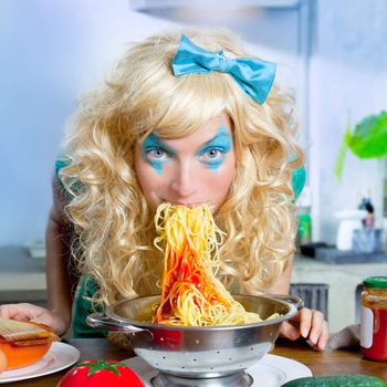 Blonde funny girl on kitchen eating pasta like crazy with blue makeup