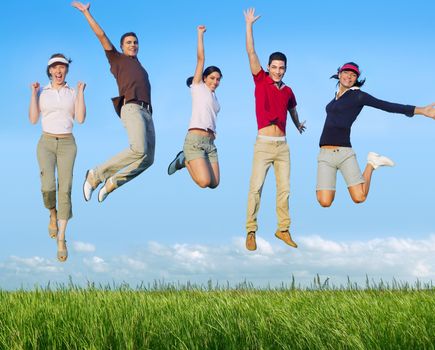 Jumping young people happy group in meadow blue sky outdoor