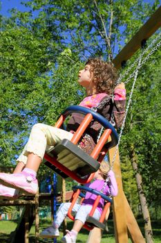 girl swinging on swing happy in trees outdoor up high