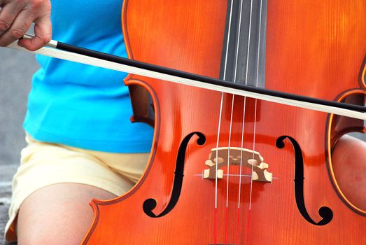 Female cellist performing a classical solo outdoors.