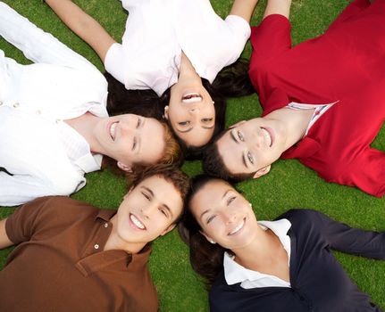friends happy group in circle heads together on green grass outdoor