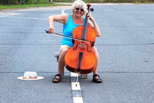 Female cellist performing a classical solo outdoors.