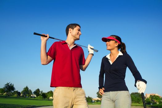 Golf course young happy players couple talking posing on bunker