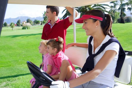 golf course family father mother and daughters on buggy in a green grass field