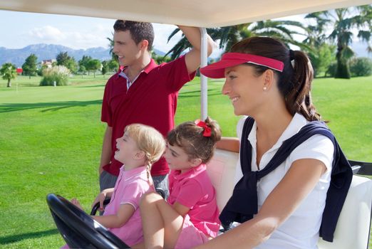 golf course family father mother and daughters in buggy green grass field