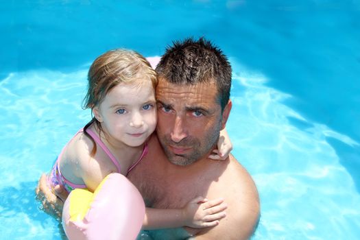 father daughter hug on blue swimming pool vacation portrait