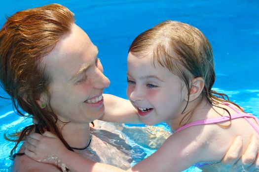 Pool mother and daughter playing together swimming lesson learning