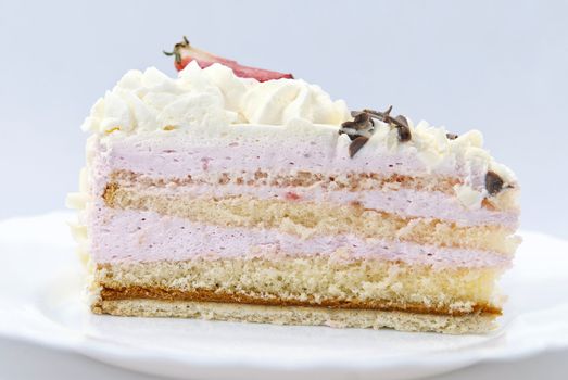 Slice of strawberry cream cake on the white plate