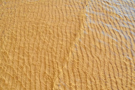 Transparent wave of the sea on the sandy beach