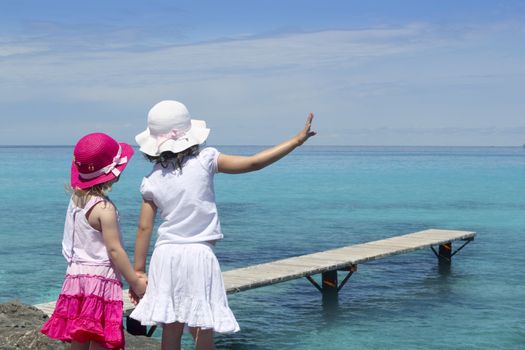 two girls tourist turquoise sea back goodbye boat hand gesture Formentera