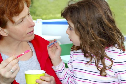 mother and daughter eating ice cream talking outdoors