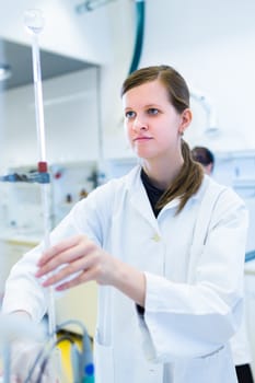 Portrait of a female researcher carrying out research in a chemistry lab (color toned image; shallow DOF)