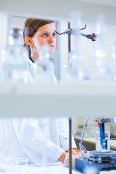 Portrait of a female researcher carrying out research in a chemistry lab (color toned image; shallow DOF)