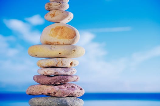 Balancing of pebbles each other on a sky background