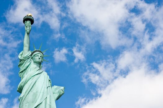 Sunnny day, blue sky with clouds: statue of Liberty with copy space