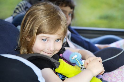 smiling little girl with safety belt on car security chair