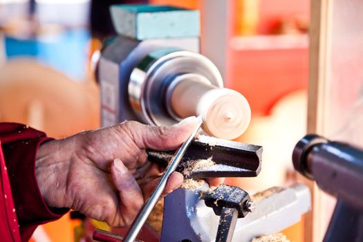 Old worker hands at lathe