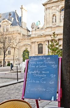 Black board with a menu restaurant in a tipical traditional square in Paris