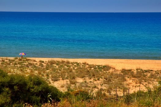 Blue sea and beach with lonely parasol