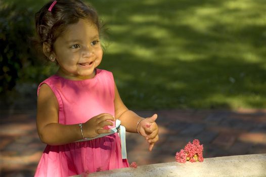 A little Indian girl plays in a fountain.