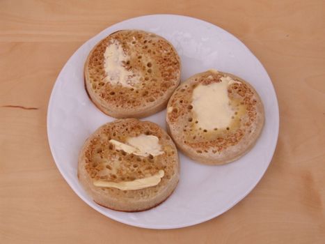 Plate of three hot buttered crumpets