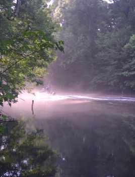 A motorboat glides past at sunset on the Santa Fe River near High Springs, Florida.